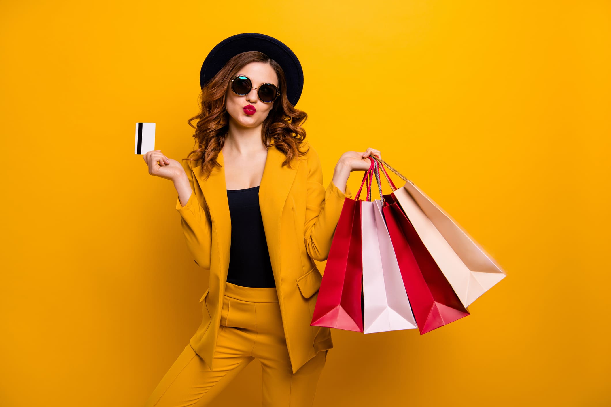 beautiful girl holding a debit card and shopping bags
