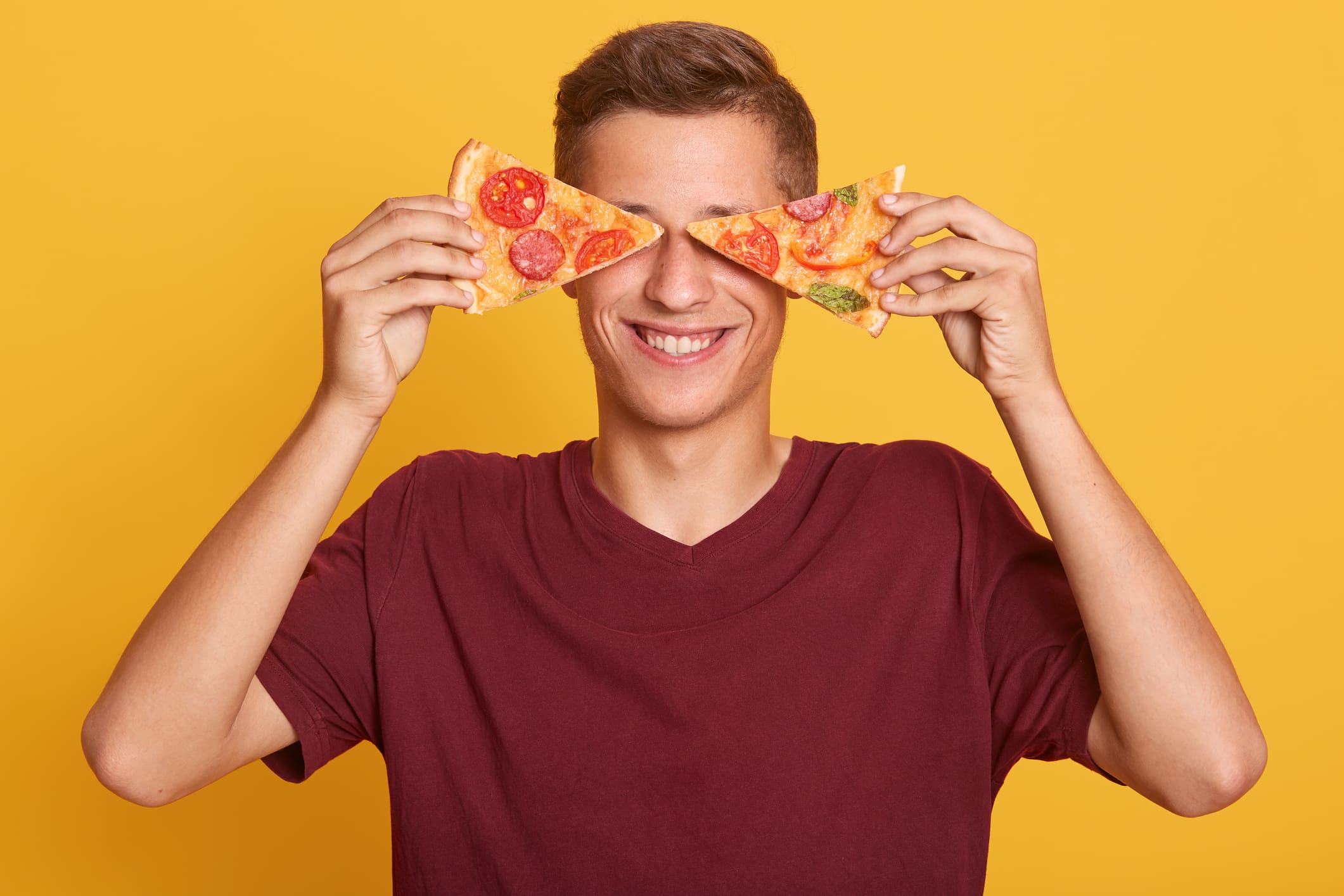 Young man holds two pieces of fresh pizza