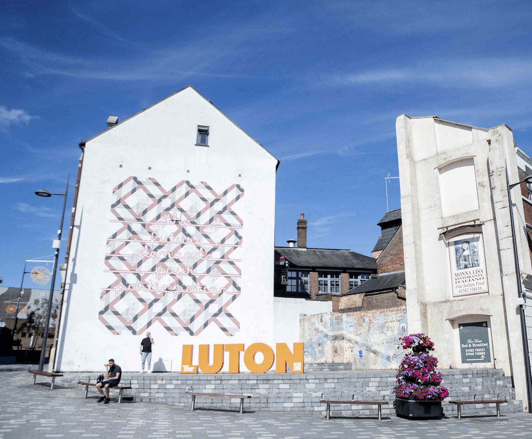 A sign saying Luton in the town's Hat District